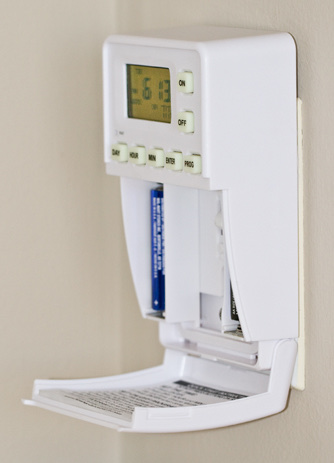 The unit with its battery door open, showing the two AA cells
